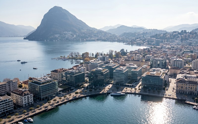 Tio.ch — Lugano, il nuovo rifugio strategico dei capitali globali · Luftaufnahme von Lugano-Paradiso mit Monte San Salvatore und dem See